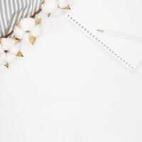 Blank white spiral notebook with white pencil on bed. photo