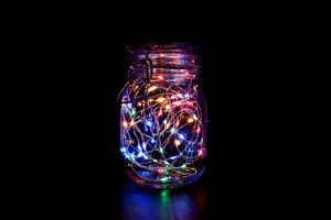 Colorful Fairy Light in a Glass Jar, in the Dark, Low-Key Photography photo