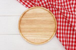 Empty round wooden plate on white wooden table. Top view image. photo