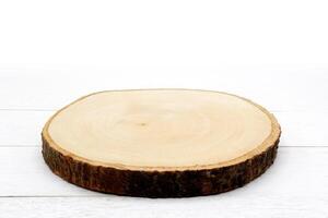 Empty rustic wooden slice serving board on white wooden table. photo