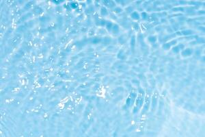Bluewater waves on the surface ripples blurred. Defocus blurred transparent blue colored clear calm water surface texture with splash and bubbles. Water waves with shining pattern texture background. photo