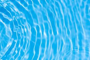 Water surface. Bluewater waves on the surface ripples blurred. Defocus blurred transparent blue colored clear calm water surface texture with splash and bubbles. Water waves with shining pattern. photo