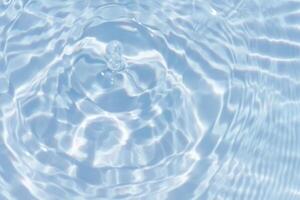 Water surface. Bluewater waves on the surface ripples blurred. Defocus blurred transparent blue colored clear calm water surface texture with splash and bubbles. Water waves with shining pattern. photo