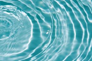 Water surface. Bluewater waves on the surface ripples blurred. Defocus blurred transparent blue colored clear calm water surface texture with splash and bubbles. Water waves with shining pattern. photo