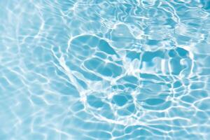 Bluewater waves on the surface ripples blurred. Defocus blurred transparent blue colored clear calm water surface texture with splash and bubbles. Water waves with shining pattern texture background. photo