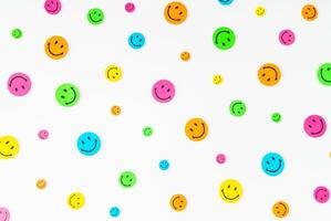 Colorful pattern composition made with smiley face stickers on white background. Minimal positive thinking and good mood concept. Mental health care recovery to happiness emotion. Flat lay. photo