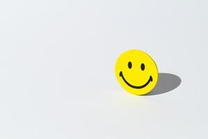 Creative layout made with smiley face sticker on white background. Minimal positive thinking and good mood concept. Mental health care recovery to happiness emotion. Copy space. photo