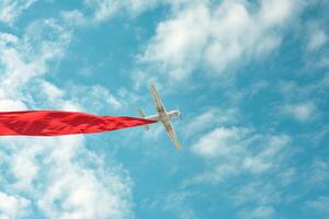 ai generado promoción avión con bandera horizontal, un rojo bandera cielo fondo, con vacío espacio para texto, para publicidad foto