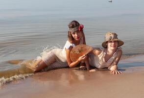 dos joven mujer en retro trajes de baño por el mar foto