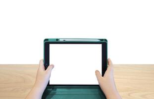 Boy's hands holding a tablet on a wooden table, white background photo