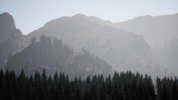 A foggy mountain with trees and mountains in the background video