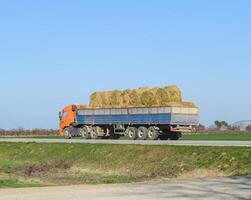 Truck carrying hay in his body. Making hay for the winter. photo