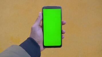 pov schot van jong Mens hand- gebruik makend van slim telefoon met groen scherm video