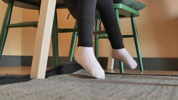 low angle view of 6 year old child girl feet with sock sitting on a chair video