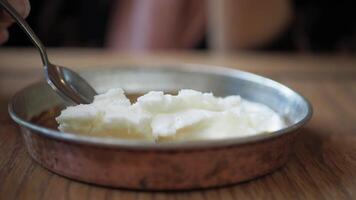 butter cream and honey in a bowl on table . video