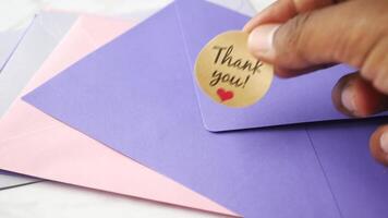 hand putting thank you sticker message on a envelope video