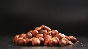 slow motion of dropping hazelnuts on black background video