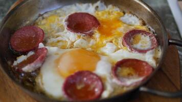 fried egg mixed with sausage on frying pan video