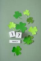 March 17 calendar and green clover leaves top view. St. Patrick's Day concept photo