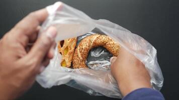 tar turkiska bagel simit ut från en plast paket video