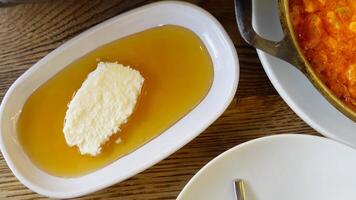 butter cream and honey in a bowl on table . video