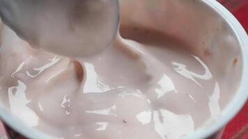 yogurt fresco in un contenitore di plastica e cucchiaio sul tavolo video