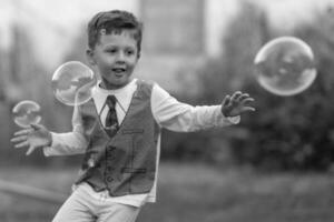 Beautiful baby boy with child soap bubbles posing photographer for cool photo