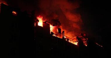 reusachtig brand laaiend in woon- gebouw. huis is overspoeld in vlammen Bij nacht gedurende de rampzalig video