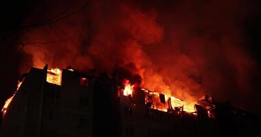 enorm brand flammande i bostads- byggnad. hus är Engulfed i lågor på natt under de katastrofal video