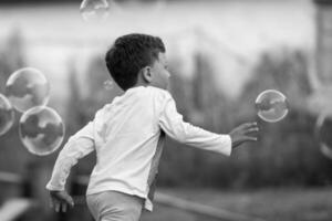 Beautiful baby boy with child soap bubbles posing photographer for cool photo