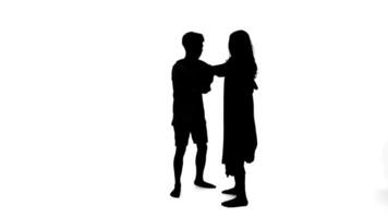 silhouette di un' uomo e donna in piedi viso per viso, possibilmente nel conversazione, isolato su bianca sfondo. video