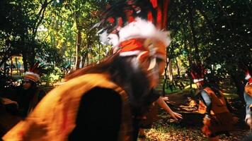 Group of children in scout uniforms playing in a sunlit forest, with focus on a girl in the foreground. video