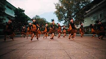 tradicional bailarines en vibrante disfraces realizar en un al aire libre ajuste con un montaña fondo. video