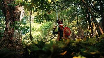 indígena pessoa dentro tradicional vestuário jogando uma tambor dentro uma exuberante floresta contexto. video