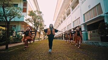 Group of young people performing a traditional dance in a courtyard with buildings video