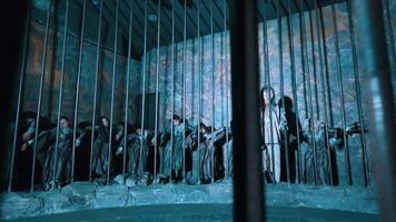 aftekenen figuren dans achter teh gevangenis met een koel blauw toon, creëren een mysterieus en griezelig atmosfeer. video