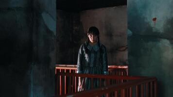 temperamental retrato de un joven mujer en pie en un puente en un tenuemente iluminado, urbano ambiente con pintada paredes video
