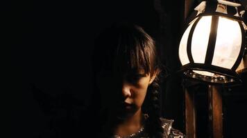 Mysterious girl by lantern light, half face in shadow, moody atmosphere video