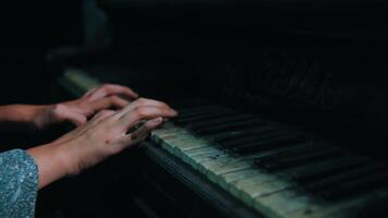 Nahansicht von Hände spielen auf ein alt, getragen Klavier Tastatur mit ein launisch, künstlerisch Stimmung. video