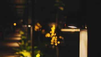 Nachtzeit Garten Weg beleuchtet durch modern LED Poller Beleuchtung, mit ein Bokeh Hintergrund. video