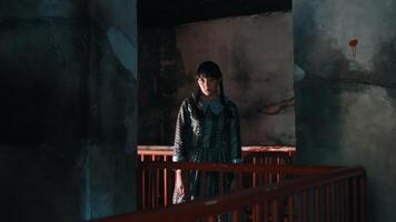 launisch Porträt von ein Person im ein dunkel, grungy Innere, Stehen durch ein rot Geländer mit Sanft Beleuchtung. video