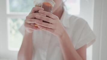 een jong vrouw zit en leent koffie Bij huis. de interieur is schoon en gemakkelijk in een minimalistische stijl. video