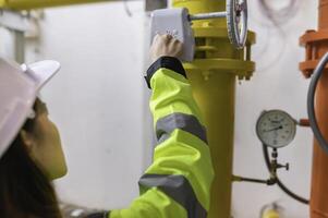 Maintenance technician at a heating plant,Petrochemical workers supervise the operation of gas and oil pipelines in the factory,Engineers put hearing protector At room with many pipes photo