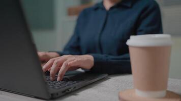 Close-up woman working on computer using touchpad typing company messages communicating with customers video