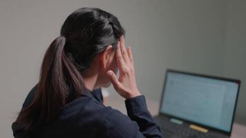 Woman reads bad news on laptop computer while sitting at work and is disappointed with notifications she receives news video