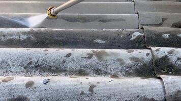 Roof cleaning with high pressure cleaner. Close- up of water pressure removing dirt. video