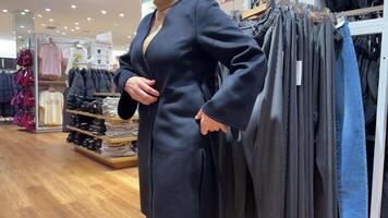 mississauga Canada 26.10.23 un' donna sceglie Abiti nel un' capi di abbigliamento negozio. video