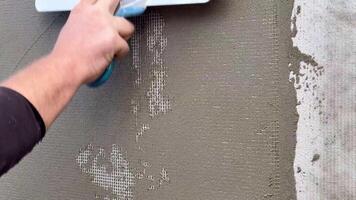 The final stage of plastering the walls. A worker levels the plaster with a metal spatula. video