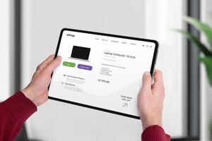 Tablet displaying e-commerce webpage, shopping for a laptop online. Modern web page concept, seamless technology, and convenient online shopping experience photo