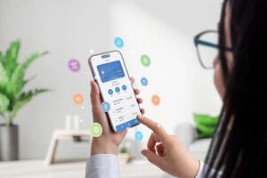 Woman hold a smartphone with a fintech app, surrounded by concept balloons featuring fintech service icons. Dynamic visuals embody modern financial technology in a user-friendly interface photo